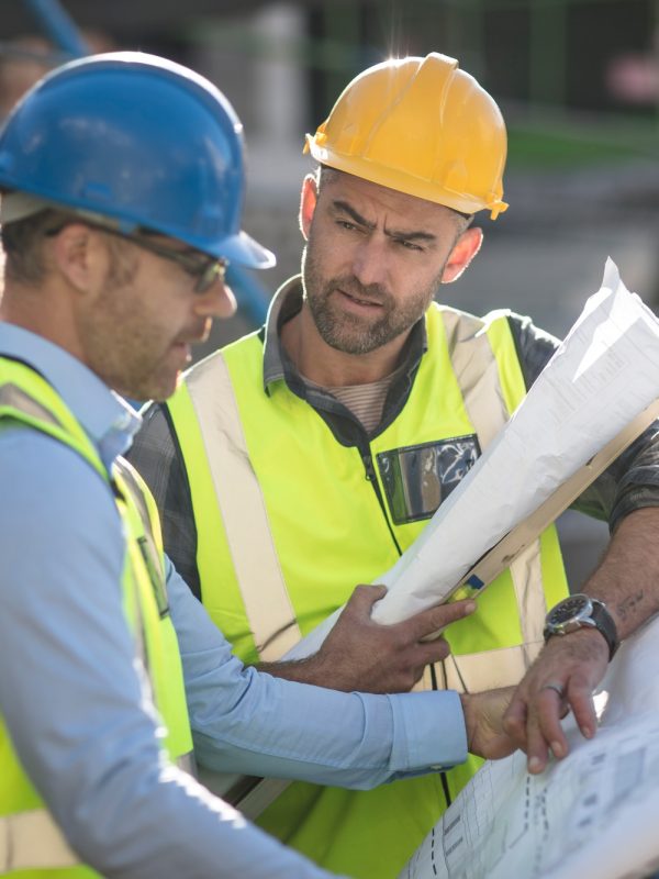 Project manager and construction worker looking at plans